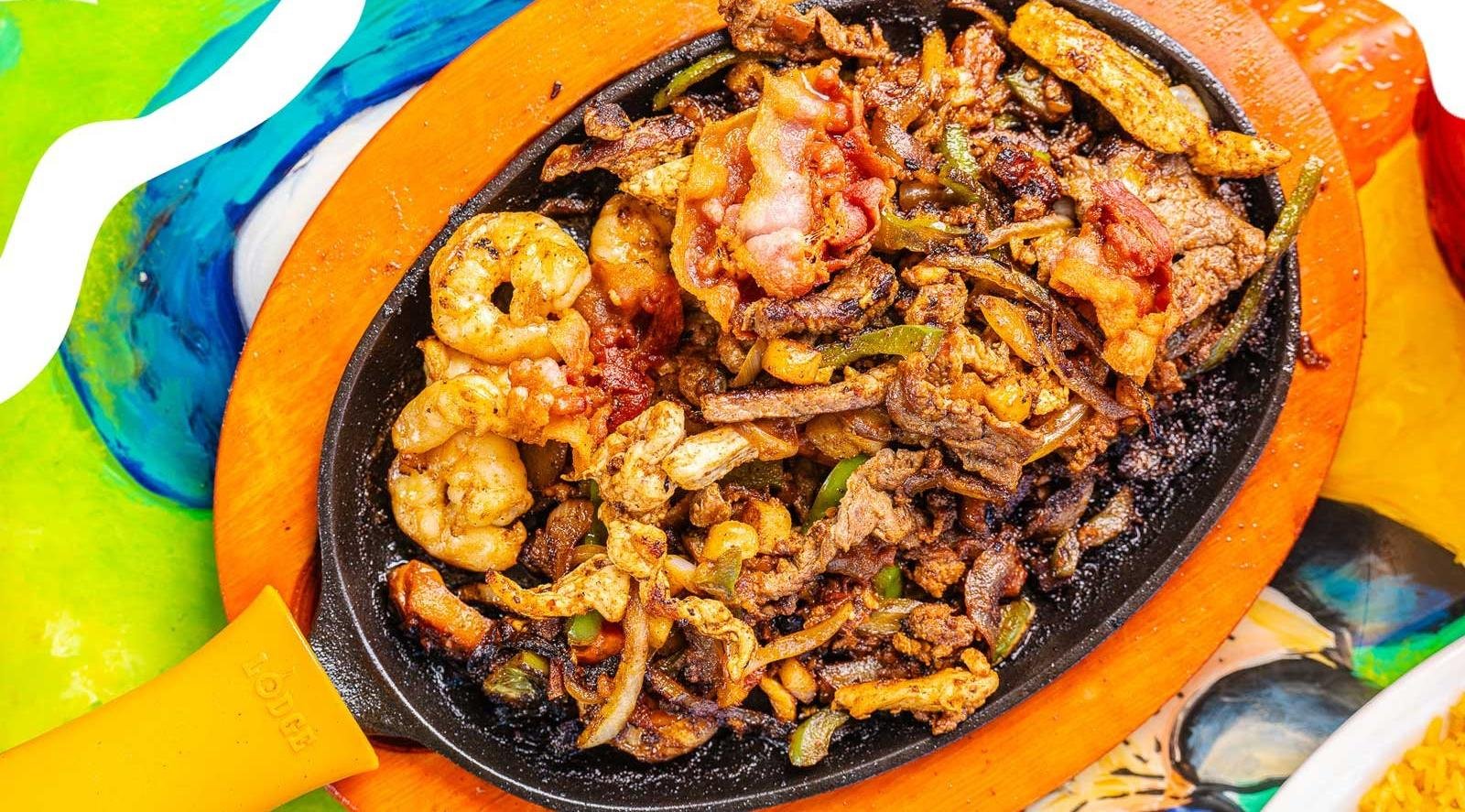 Sizzling fajitas with shrimp and steak on a colorful sarape
